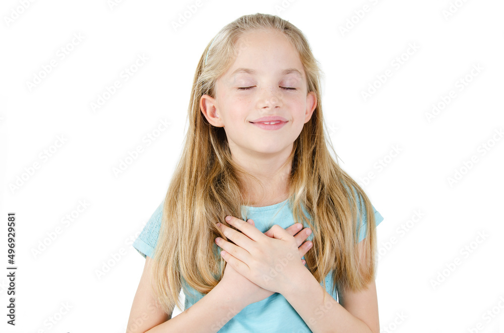 Little sincere adorable girl closed eyes holding hands on chest feeling gratitude pose isolated on white background, arms on heart gesture of love appreciation gratitude, adoption concept