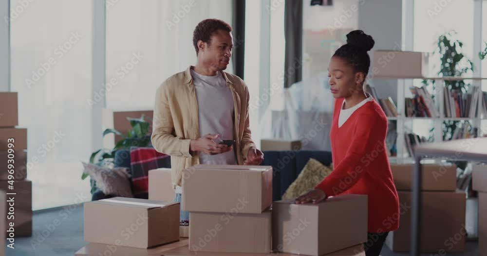 Joyful excited couple of married afro-american man with woman counting cardboard boxes with furniture in empty old apartment. Moving house. Joyful excited couple of married afro-american man with woman counting cardboard boxes with furniture in empty old apartment. Moving house.