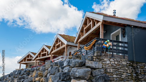 traditional scandinavian lodges on rocks blue sky with clouds