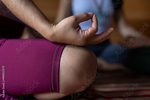 Hand of young Latin American woman seated in meditation position. Selective focus on the hand. Meditation and yoga concept.