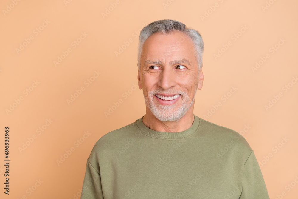 Photo of mature cheerful man curious interested look empty space idea isolated over beige color background Photo of mature cheerful man curious interested look empty space idea isolated over beige color background