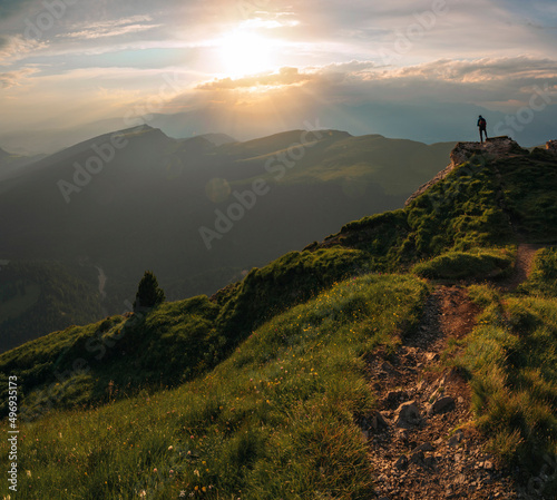 Backpacker, traveler standing on the dolomite mountain during sunset in Alps, Italy. © valdisskudre