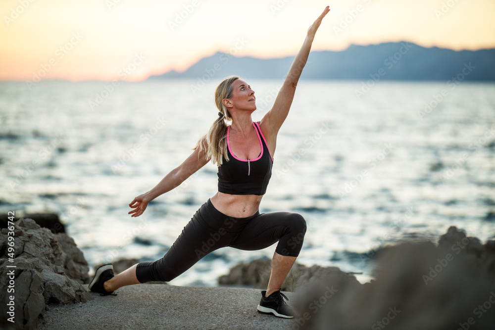 Woman Practicing Yoga Near The Sea Beach