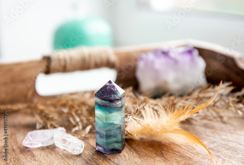 Translucent Fluorite crystal standing point gemstone in home bed room on natural wood tray. Healing and clearing energy concept. photo