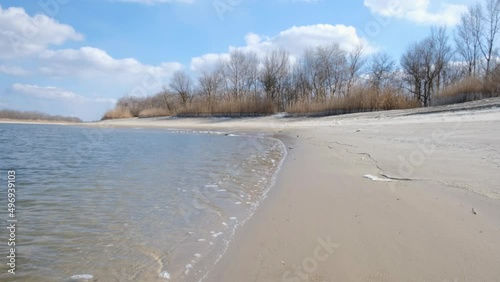 Winter landscape. An empty beach on the eve of spring. Waves on the water and cold sand. It's springtime, snow and ice are melting. The nature of the left bank of the Don River. Stanitsa Romanovskaya. photo