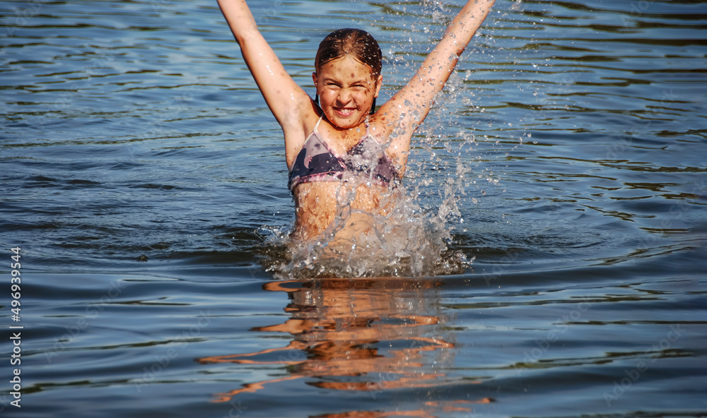Fototapeta premium girl in a bathing suit on the sea, a happy child on a sea holiday