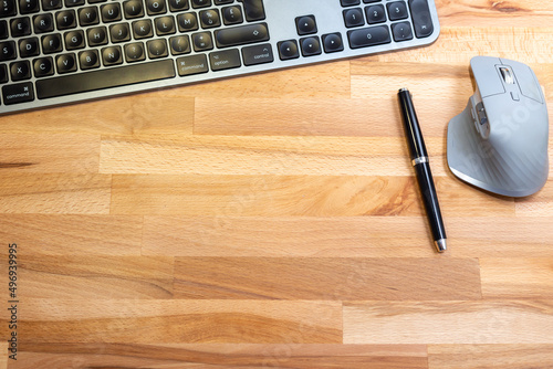 Bureau en bois avec clavier souris et stylo plume photo