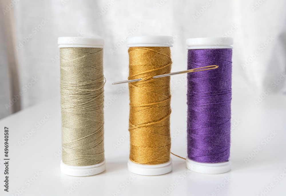 Spools of thread with a needle . Sewing workshop, atelier. Spools of thread with a needle . Sewing workshop, atelier.