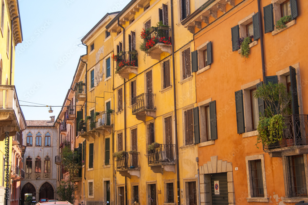 Yellow orange houses in Verona with plants on the balconies