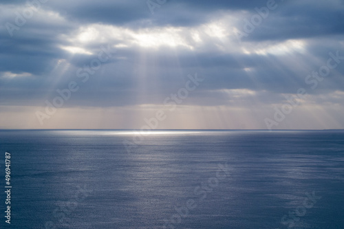 Sun rays through cloud cover on sea