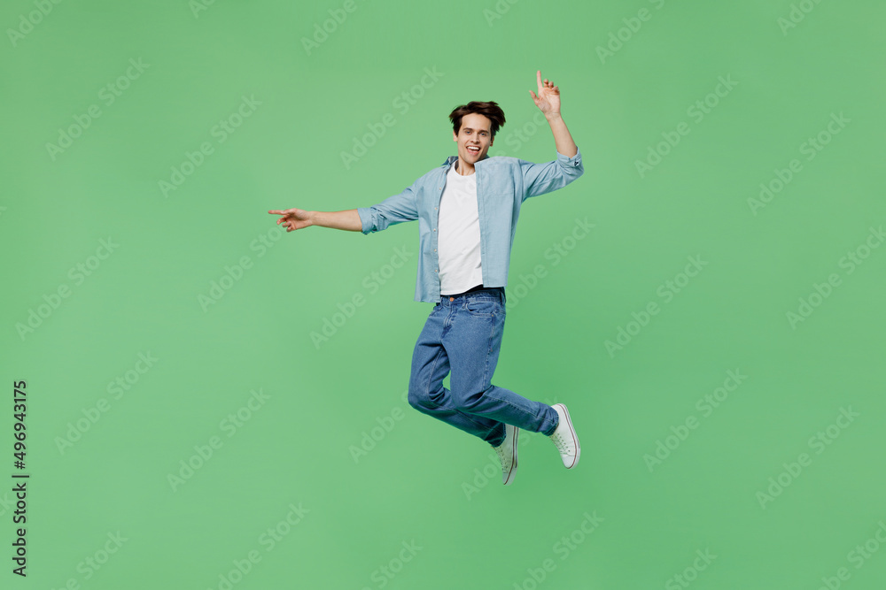 Full size body length insighted smart proactive jubilant young brunet man 20s years old wears blue shirt holding index finger up with great new idea isolated on plain green background studio portrait.