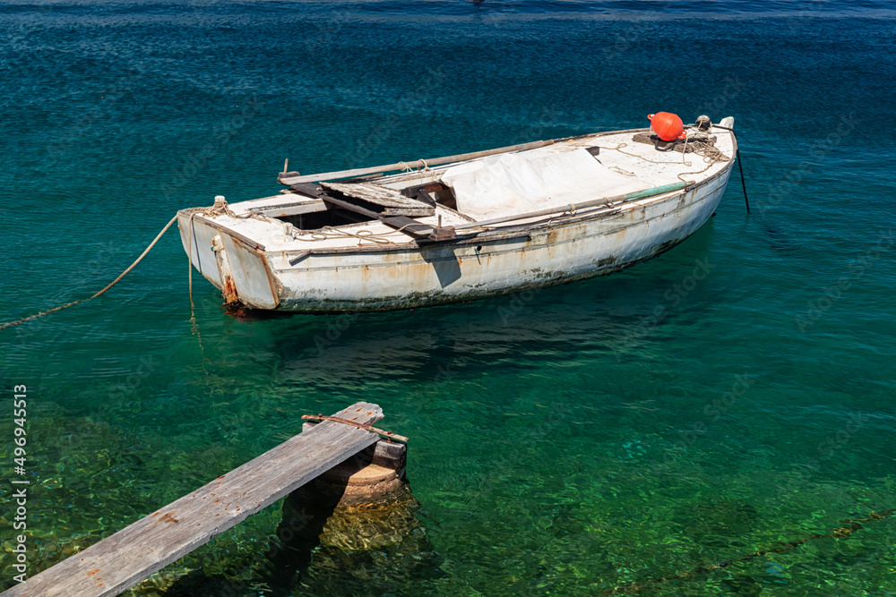 Naklejka premium boat moored at the wooden pier in harbour of Losinj town, Croatia.