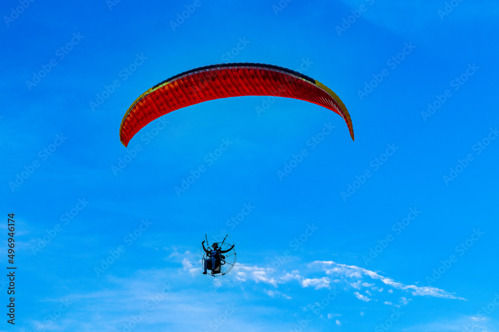 Paragliding flight with engine under blue sky. Paragliding flight with engine under blue sky.