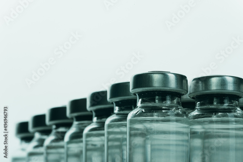 Glass medical ampoule vial for injection. Medicine is liquid sodium chloride with of aqueous solution in ampulla. Close up. Bottles ampule multicolor on background color and water. Human plasma.