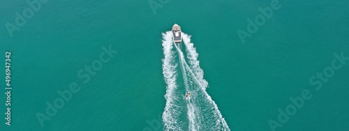 Aerial drone ultra wide panoramic photo with copy space of extreme power boat water-sports cruising in high speed in tropical emerald bay © aerial-drone