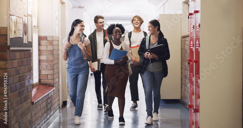 Keep learning, keep moving forward. Shot of a group of teenagers walking down the hall at high school.