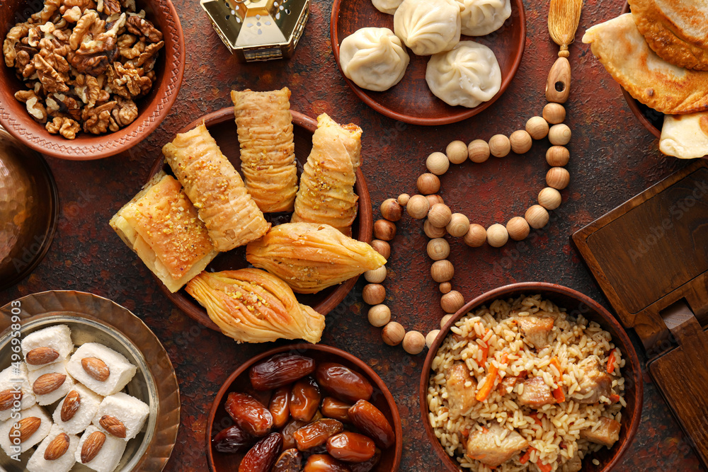 Fototapeta premium Traditional Eastern dishes with tasbih on color background