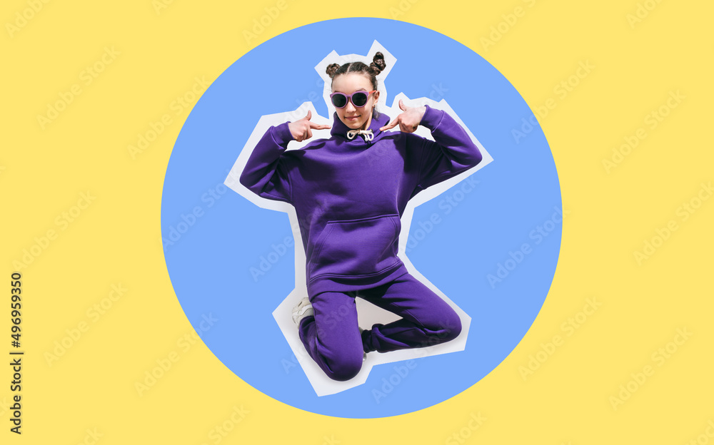 Cute teen girl in a purple casual sports suit hoodie and pants and white sneakers posing over yellow background. Mock-up for print. Cute teen girl in a purple casual sports suit hoodie and pants and white sneakers posing over yellow background. Mock-up for print.