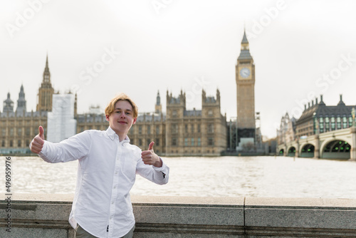 student in London  stands on the riverside, London parliament on the background photo