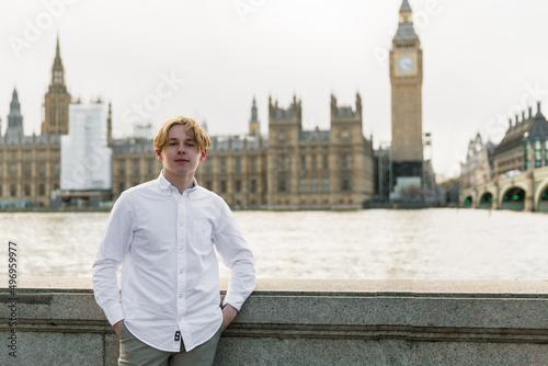 Young man  in London  stands on the riverside, London parliament on the background photo