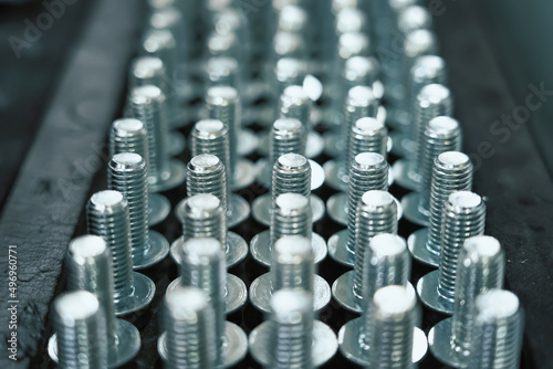 Many metal screw bolts as industrial equipment background. photo