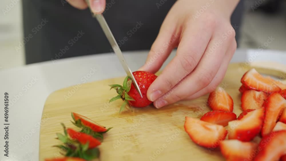 strawberries are cut into pieces on a wooden cutting board to decorate desserts. strawberries are cut into pieces on a wooden cutting board to decorate desserts.
