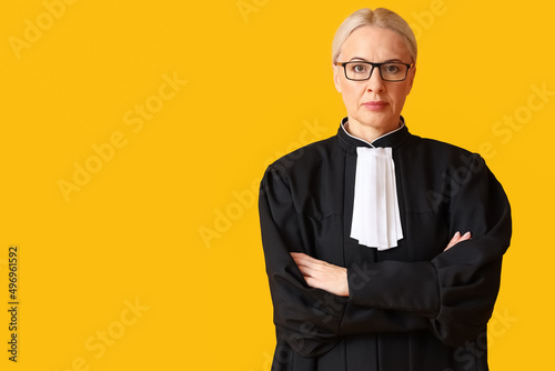 Canvastavla Mature female judge in robe on yellow background