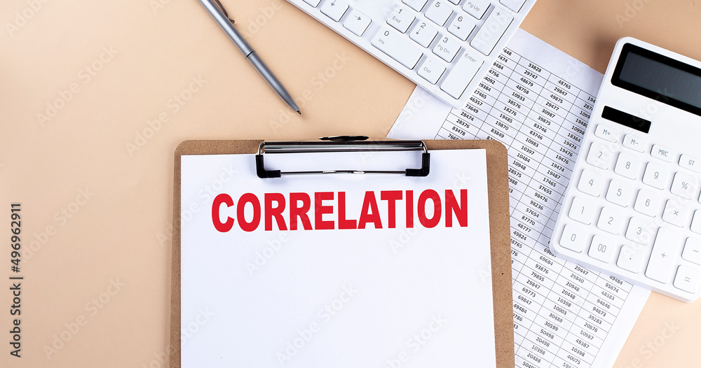 Fototapeta clipboard with white blank paper text CORRELATION , keyboard calculator and chart, top view