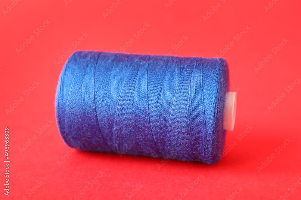 Blue sewing thread spool on color background Blue sewing thread spool on color background