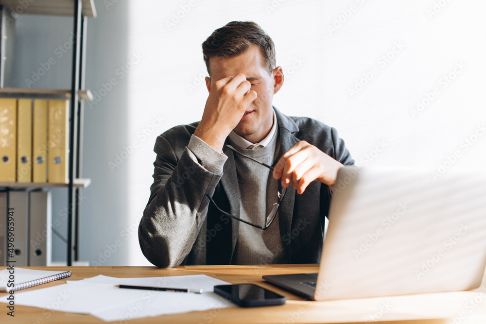 Modern man with glasses, office worker tired at work Modern man with glasses, office worker tired at work