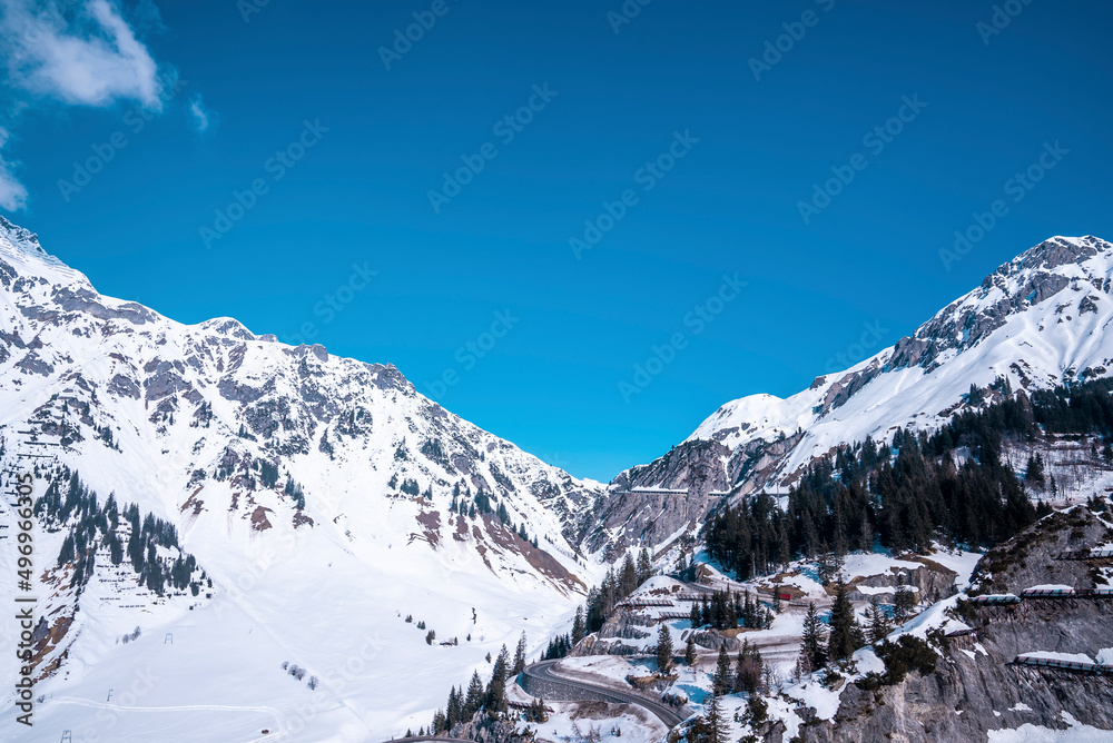 Avalanche barriers on snow covered mountain. Protective fence over roads. Scenic landscape against blue sky.