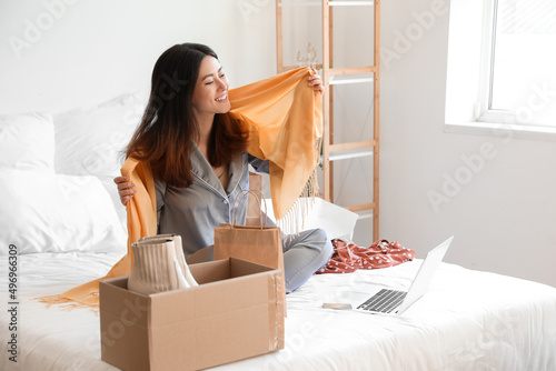 Happy young woman unboxing ...