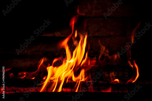 Fire on a black background. Red, orange and yellow flames and sparks on a dark background. Bonfire, fireplace, hearth or fire.