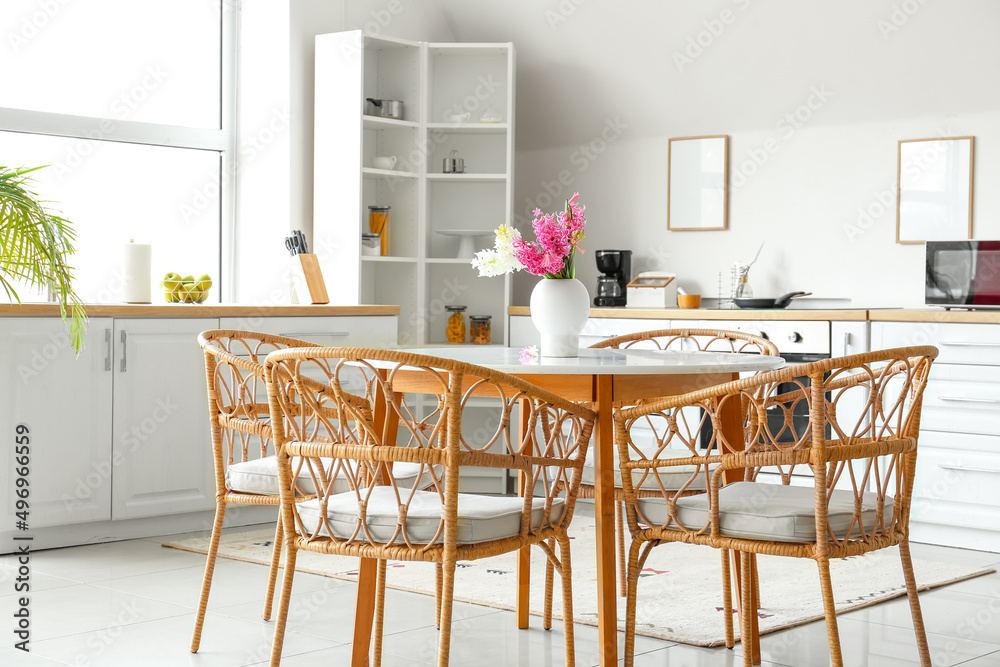 Stylish interior of kitchen with dining table and hyacinth flowers Stylish interior of kitchen with dining table and hyacinth flowers
