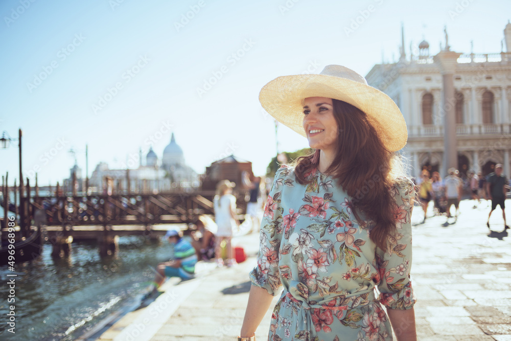 happy modern woman in floral dress with hat having excursion