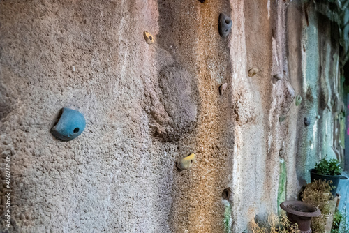 Artificial mountain climbing practice. Footholds on textured wall. Strength training in resort.