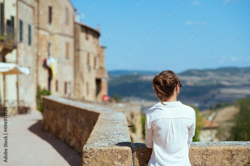 Seen from behind trendy solo traveller woman in Tuscany, Italy