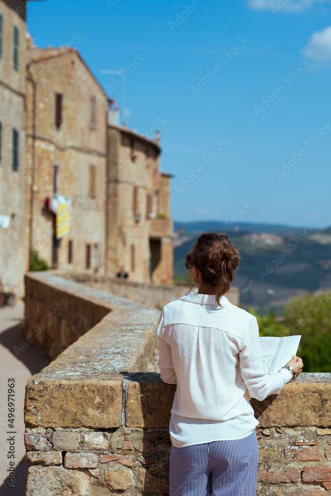 Seen from behind young woman in Pienza in Tuscany, Italy