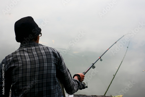 rear view person fishing in the pond