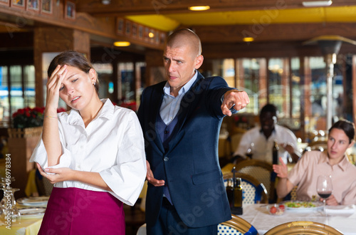 Konstfotografi Angry man client of restaurant yelling at young waitress chasing her away