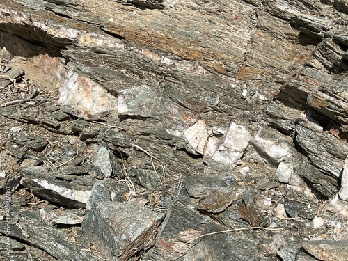 A layer of quartz stone embedded within layers of schist rock in a desert canyon in Southern California photo