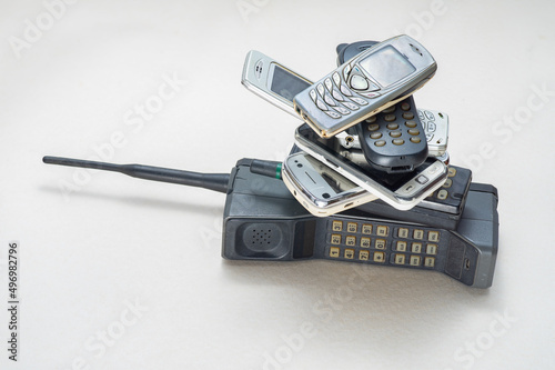 Pile of old and obsolete mobile phones on space of bright and rough background