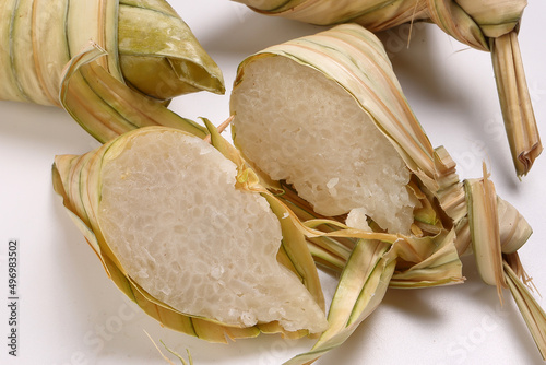 Traditional diamond shaped woven palm leaf pouch steamed glutenous rice cake ketupat kupat tipat on white background photo