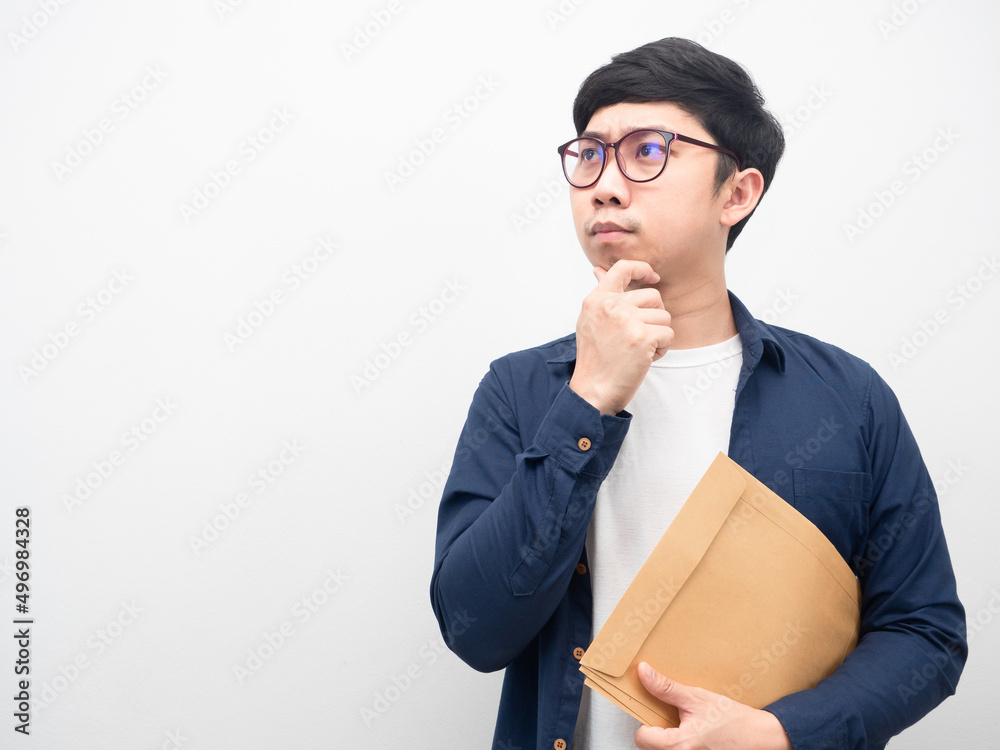 Man wearing glasses holding document envelope gesture thinking looking at copy space Man wearing glasses holding document envelope gesture thinking looking at copy space