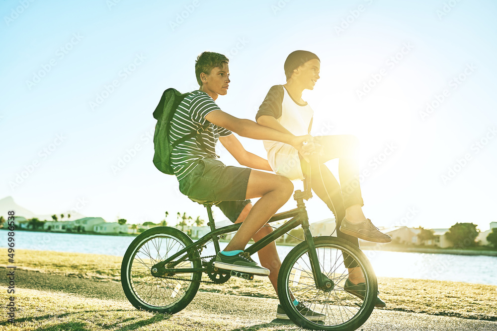 Obraz premium Its all about the downhill. Full length shot of a young boy giving his younger brother a lift on a bicycle outside.