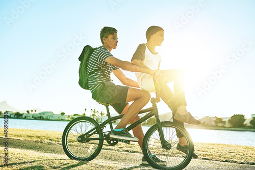 Its all about the downhill. Full length shot of a young boy giving his younger brother a lift on a bicycle outside.