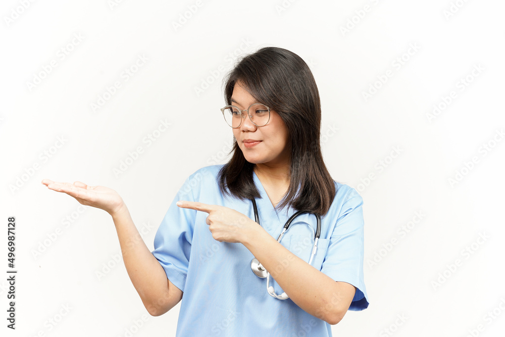Showing and Pointing Product With Thumb Of Asian Young Doctor Isolated On White Background Showing and Pointing Product With Thumb Of Asian Young Doctor Isolated On White Background