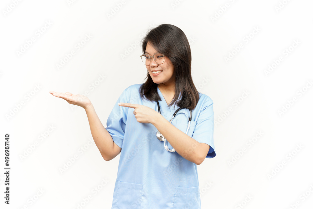 Showing and Pointing Product With Thumb Of Asian Young Doctor Isolated On White Background Showing and Pointing Product With Thumb Of Asian Young Doctor Isolated On White Background