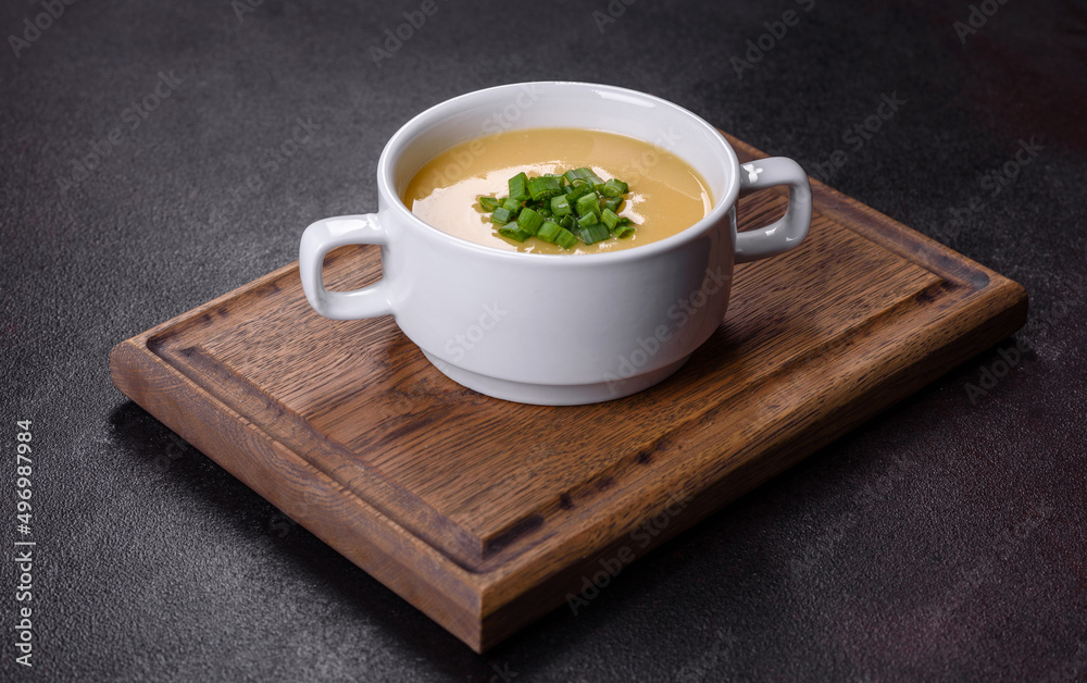 Cream soup with potatoes, leek and peas on a dark concrete table Cream soup with potatoes, leek and peas on a dark concrete table