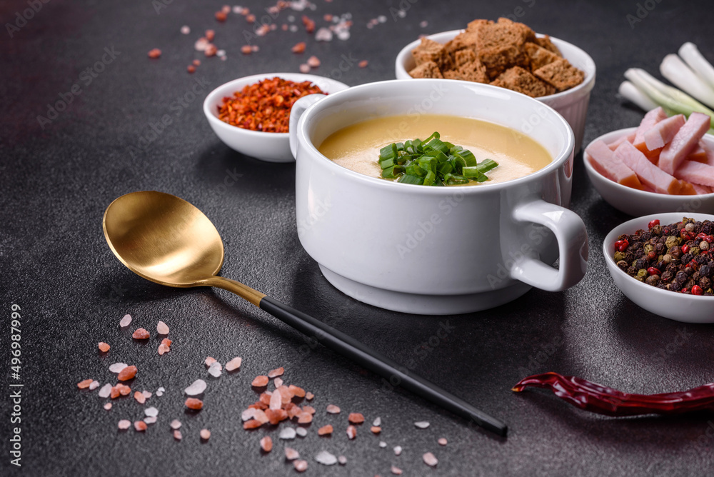 Cream soup with potatoes, leek and peas on a dark concrete table Cream soup with potatoes, leek and peas on a dark concrete table